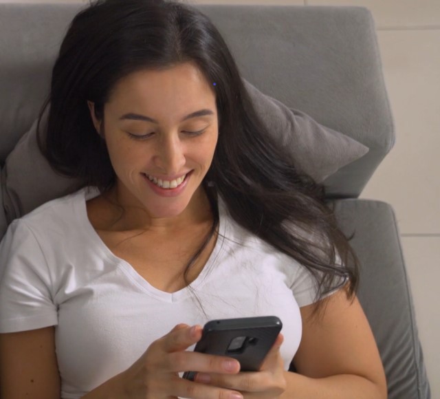 A woman using her phone on a couch