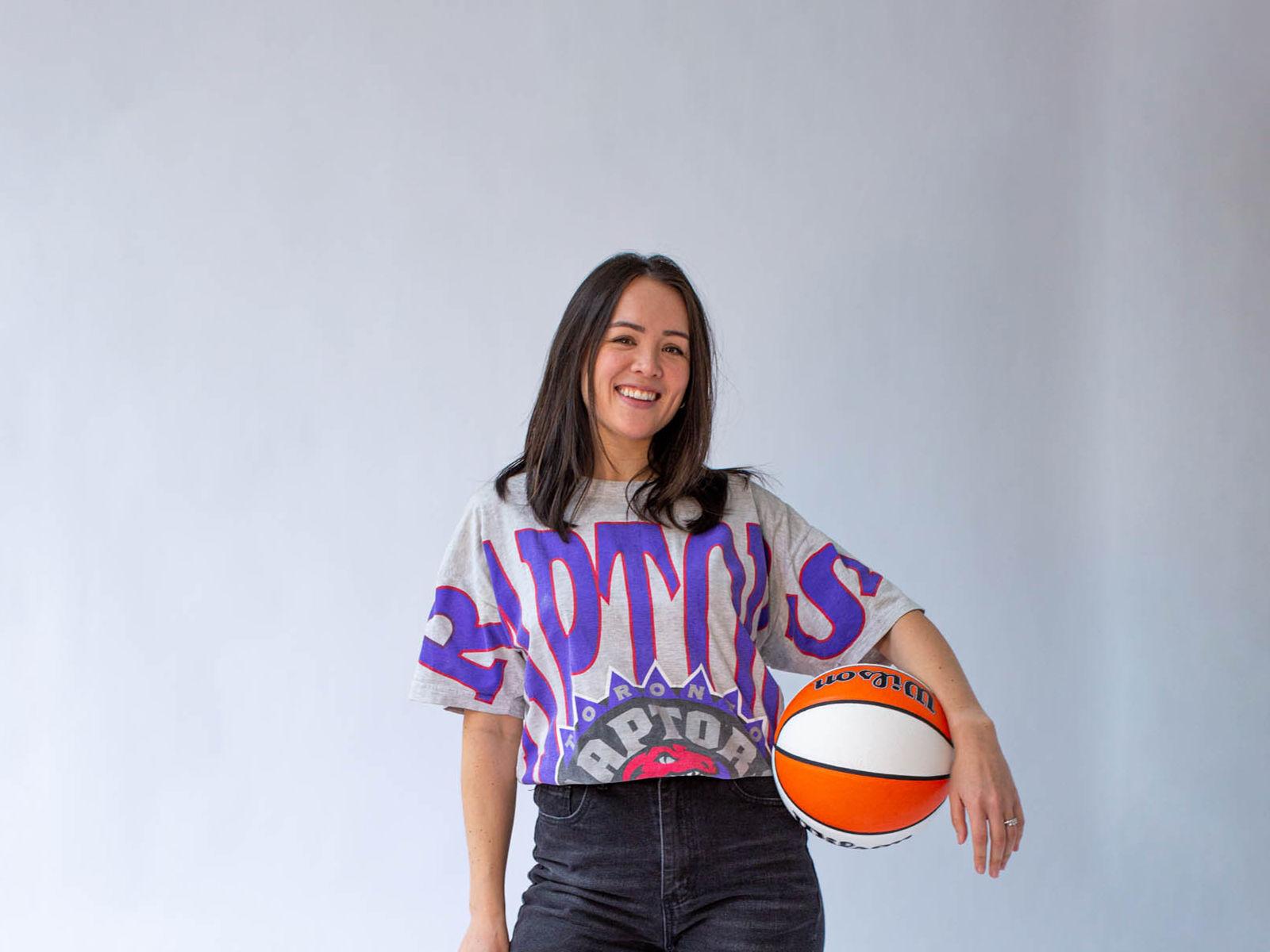 Jacie deHoop, cofondatrice de The Gist, posant avec un haut des Toronto Raptors et un ballon de basket à la hanche.