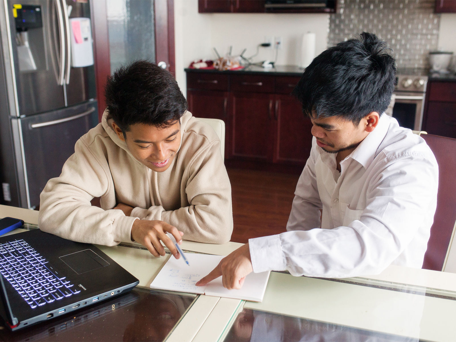 A father teaching his son some basic financial concepts at the dinner table.