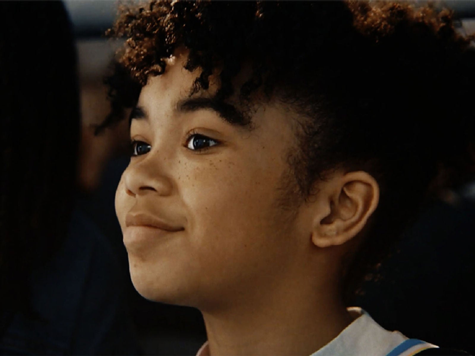 A smiling young girl watching a WNBA game.