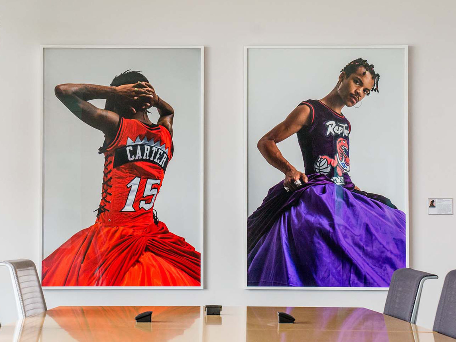 Two large Pride-themed portraits of Toronto Raptors players wearing gowns, in a Tangerine conference room.