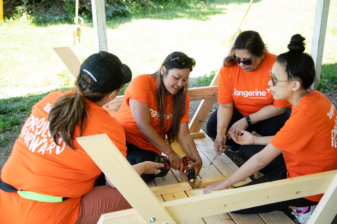 Four Tangerine employees building a picnic table 