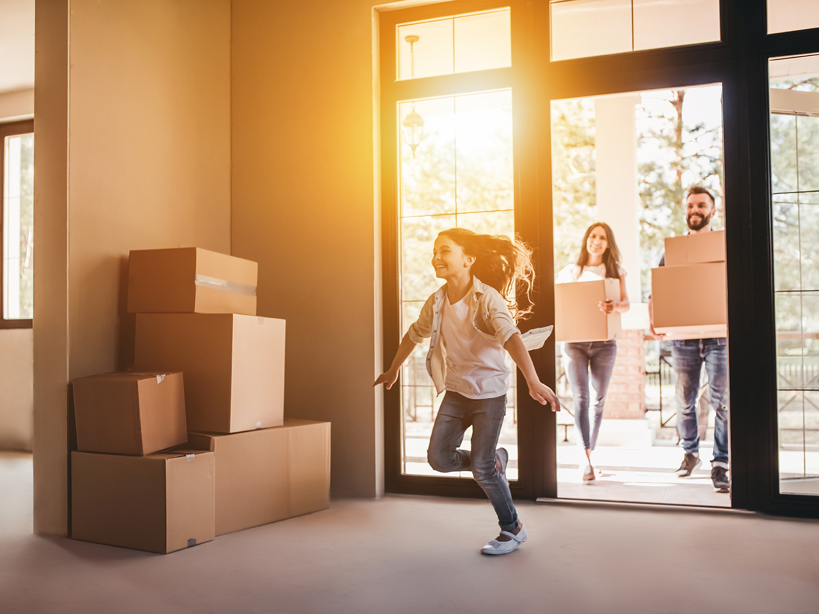 Une famille heureuse avec des cartons dans sa nouvelle maison le jour du déménagement.