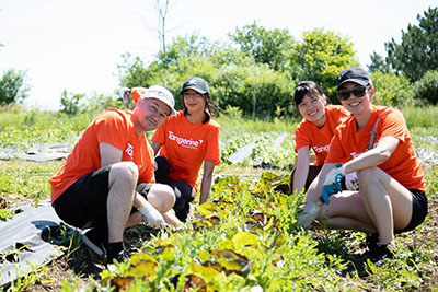 Four Tangerine employees who paused their work on the farm to smile at the camera